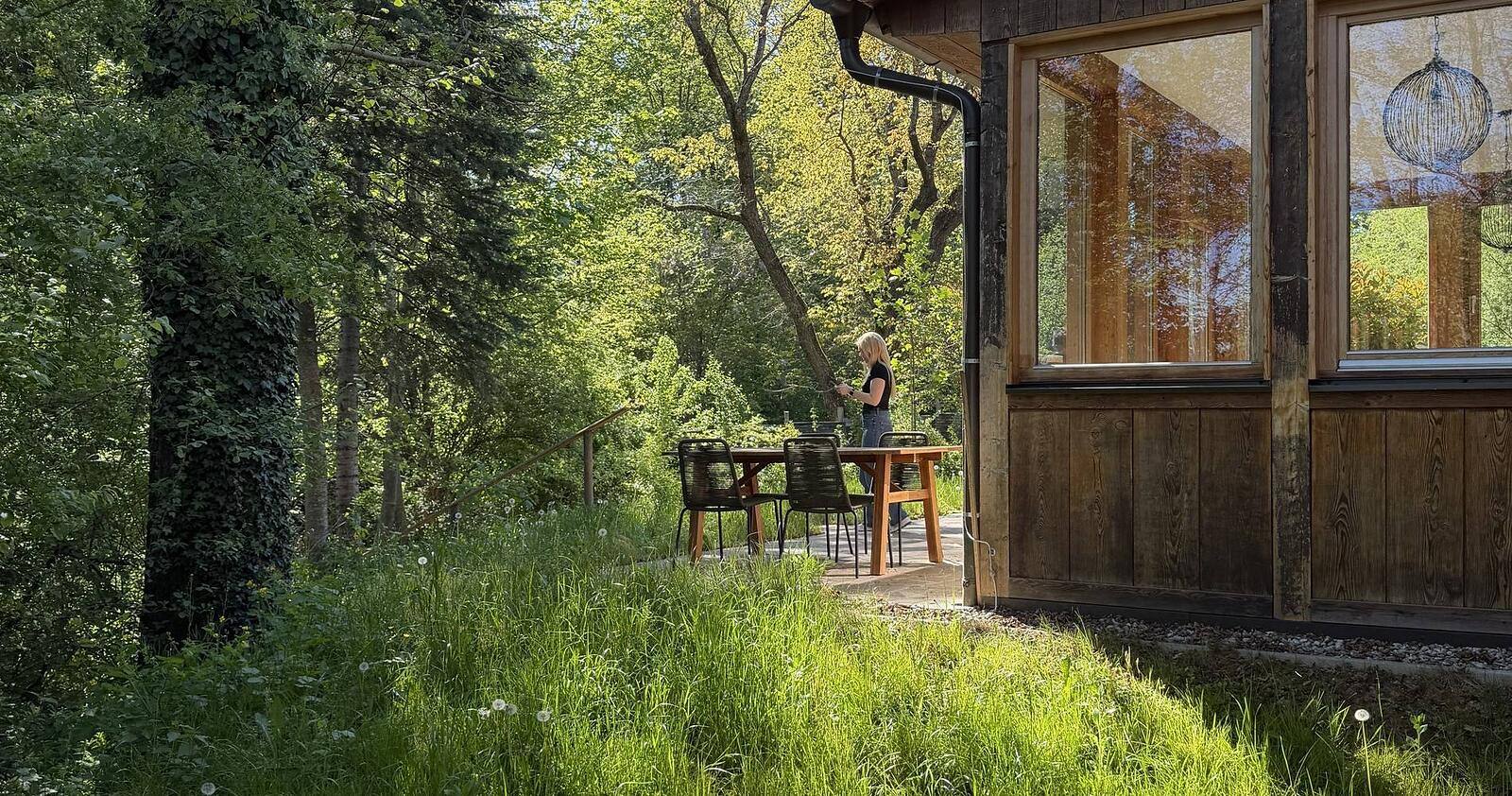 Gedeckter Tisch auf der Terrasse des Ferienhauses Johann & Anna, umgeben von Wiese und Wald