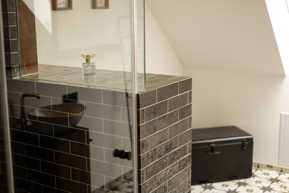 Dusche mit dunklen Fliesen in der Wohnung Steiermark