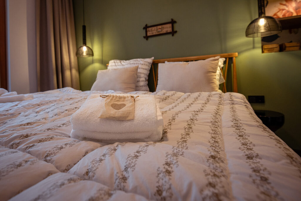 Schlafzimmer der Wohnung Johann mit bezogenem Doppelbett und frischen Handtüchern