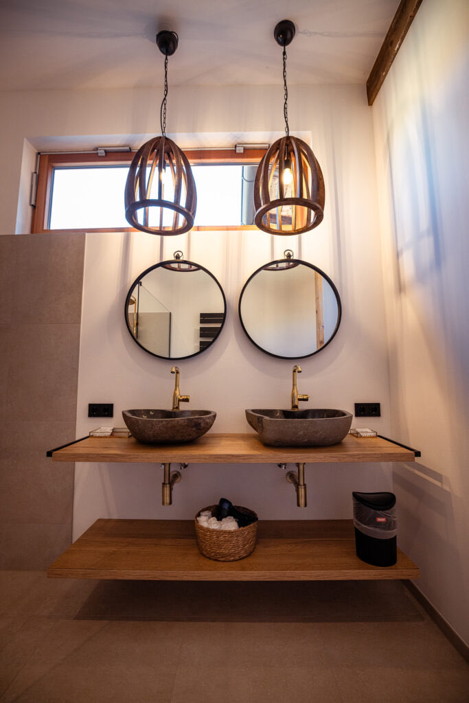 Badezimmer der Wohnung Johann mit Doppelwaschtisch und zwei runden Spiegeln
