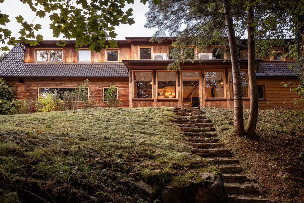 Außenansicht des Ferienhauses mit Wiese und Aufgang zur Wohnung Anna
