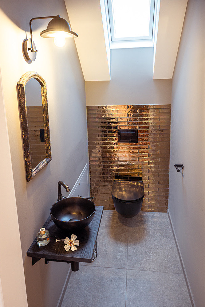 Badezimmer der Wohnung Fuchs mit Ziegelwand und Aufsatzwaschbecken