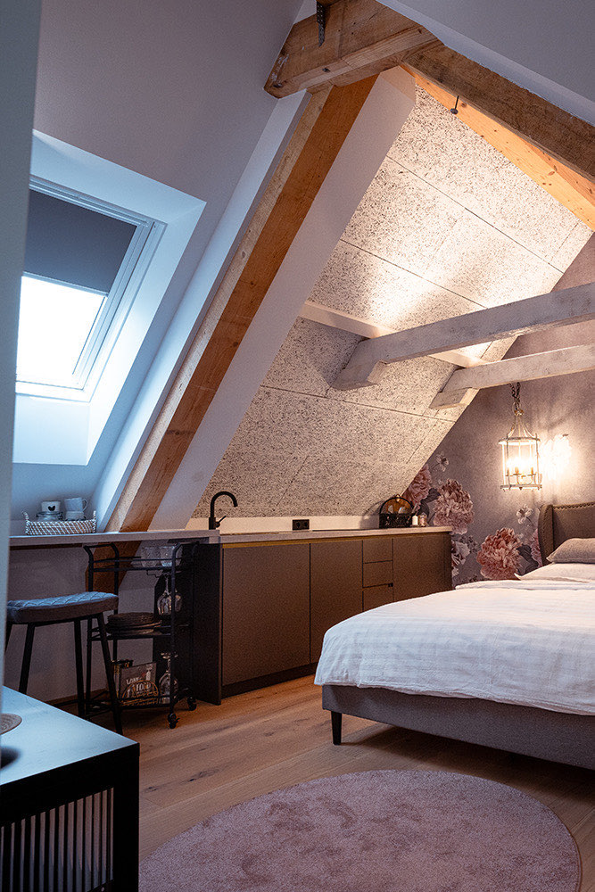 Schlafbereich der Wohnung Steiermark mit Dachfenster und Sitzecke