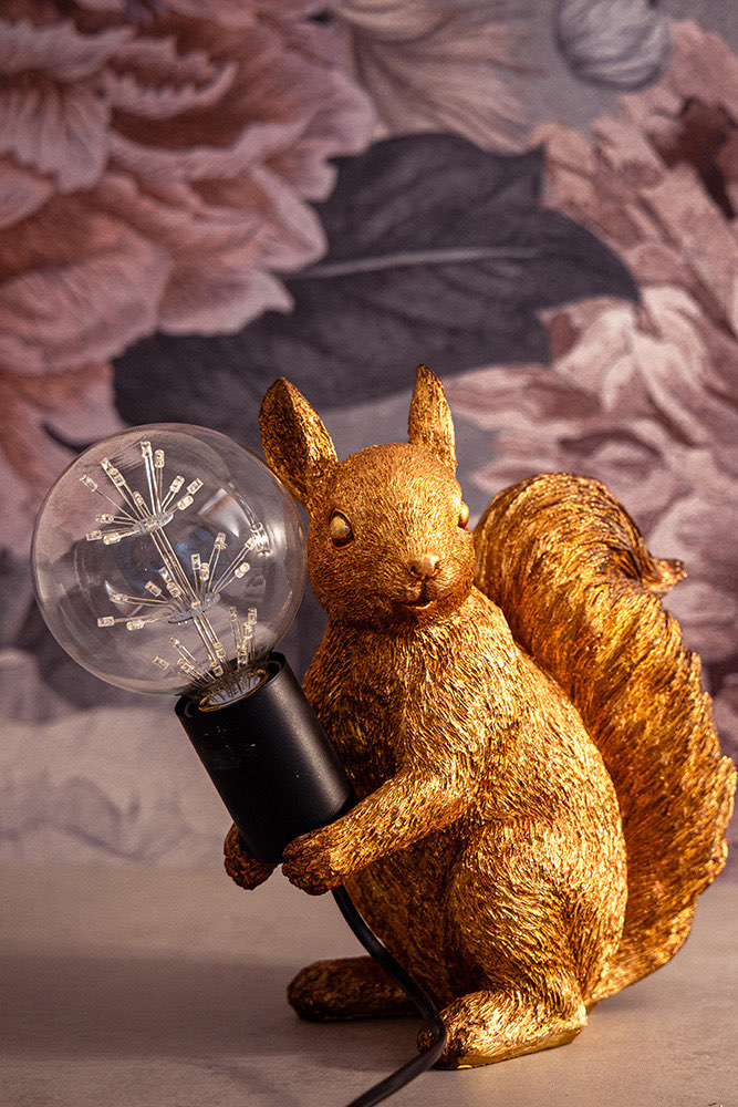 Tischlampe mit Eichhörnchen-Figur vor Blumentapete in der Wohnung Steiermark