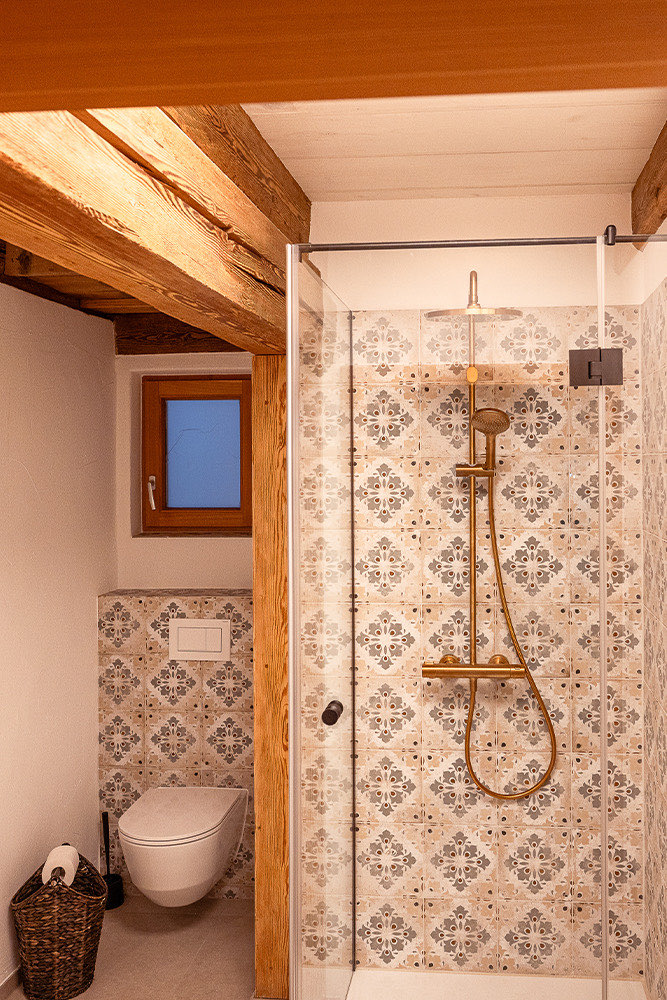 Badezimmer der Wohnung Anna mit gemusterten Fliesen und Dusche
