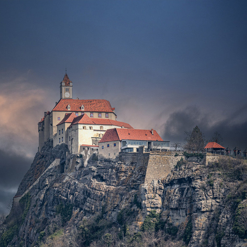 Die Burg Riegersburg auf ihrem Vulkanfelsen unter dunklem Himmel